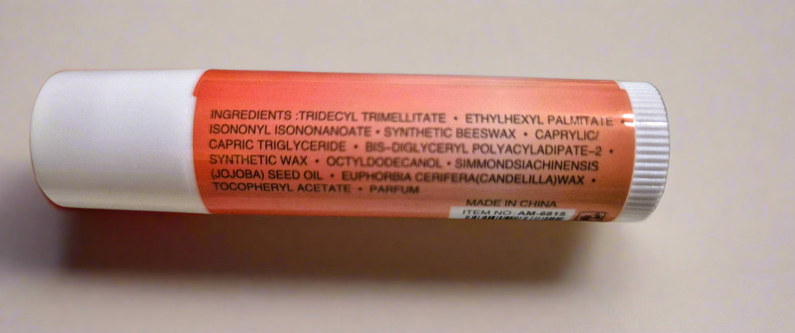 Lip balm with an orange label showing ingredients on a beige background