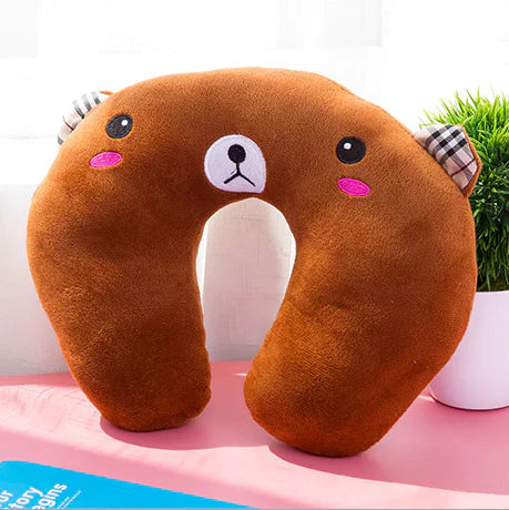 Brown cartoon neck pillow on a pink surface with a white background