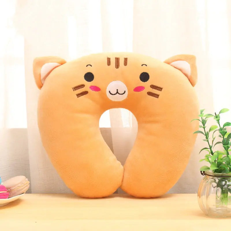 Cat-shaped neck pillow on a light surface with a plant in the background