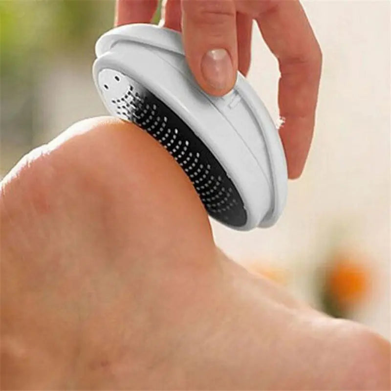 Person using a gray and black foot scrubber on their foot with a blurred background